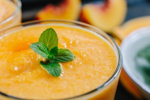 Orange smoothie with leaves of fresh mint